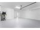 Bright garage with a gray sealed floor, water heater, utility sink, and access door to the home at 31764 Griffin Sands Ln, San Antonio, FL 33576