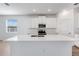 An open kitchen with a large island, white cabinets, and stainless steel appliances at 31764 Griffin Sands Ln, San Antonio, FL 33576