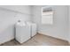 Laundry room featuring a washer, dryer, wooden-look floors and a window allowing for natural light at 31764 Griffin Sands Ln, San Antonio, FL 33576