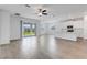 Open-concept living room with luxury vinyl flooring, sliding glass doors and modern white kitchen at 31764 Griffin Sands Ln, San Antonio, FL 33576