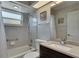 Bathroom featuring white tub, tile walls, and dark vanity with chrome faucet at 334 Northway Dr, Sun City Center, FL 33573