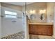 Bathroom featuring tiled walk-in shower with pebble floor and dual sinks with granite countertop at 334 Northway Dr, Sun City Center, FL 33573