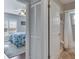 View of a bedroom with shuttered windows and light blue bedding and ensuite bathroom through an open doorway at 334 Northway Dr, Sun City Center, FL 33573