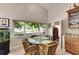 Bright dining area with vaulted ceilings and views of the backyard and adjacent park at 334 Northway Dr, Sun City Center, FL 33573