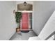 Inviting front entry with a vibrant red door, overhead window, and decorative plant at 334 Northway Dr, Sun City Center, FL 33573