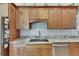 A close up of kitchen cabinets, marble countertops, a sink and modern appliances at 334 Northway Dr, Sun City Center, FL 33573