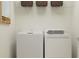 Functional laundry room with white washer and dryer, storage shelves, and neutral wall color at 4023 Northern Key Dr, Plant City, FL 33563