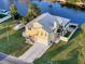 Aerial view of yellow two-story home with a metal roof, and waterfront access on a clear day at 4116 Diaz Ct, Hernando Beach, FL 34607