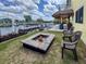 Waterfront backyard features a fire pit, chairs, and a tiki bar for outdoor enjoyment at 4116 Diaz Ct, Hernando Beach, FL 34607