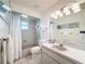 Bathroom with tub, white shower curtain, and ample lighting above the vanity mirror at 4116 Diaz Ct, Hernando Beach, FL 34607