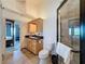 Well-lit bathroom with a wooden cabinet and glass shower. Bedroom visible in the background at 4116 Diaz Ct, Hernando Beach, FL 34607