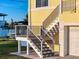 Close-up of home's staircase entrance and a boat parked nearby on the well-maintained lawn at 4116 Diaz Ct, Hernando Beach, FL 34607