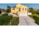 Charming yellow two-story home with a well-manicured lawn, driveway, and a boat parked on the side at 4116 Diaz Ct, Hernando Beach, FL 34607