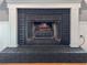 Close up of a painted brick fireplace with white mantle and safety screen at 4116 Diaz Ct, Hernando Beach, FL 34607