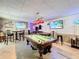 Finished basement featuring a pool table, bar area, and large screen televisions for entertainment at 4116 Diaz Ct, Hernando Beach, FL 34607