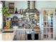 Charming kitchen with stainless steel range, floating shelves, tile backsplash, and granite countertops at 4116 Diaz Ct, Hernando Beach, FL 34607