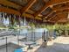 Outdoor space featuring tiki bar, dock, canal, and seating areas perfect for relaxing at 4116 Diaz Ct, Hernando Beach, FL 34607