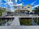 Back of waterfront home features private dock, tiki bar, patio, and ample outdoor seating, great for entertaining at 4116 Diaz Ct, Hernando Beach, FL 34607