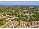 An aerial view shows townhomes surrounded by lush trees and neighborhood streets on a sunny day at 456 Lakeview Dr # 5, Palm Harbor, FL 34683