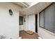 Front entrance with an open white door, a 'Welcome' mat, and a charming exterior at 456 Lakeview Dr # 5, Palm Harbor, FL 34683