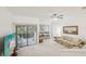 Spacious living room with a ceiling fan, slider doors, and carpeted floors at 456 Lakeview Dr # 5, Palm Harbor, FL 34683