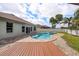 Inviting backyard showcasing a pool, spa, wood deck and lush landscaping at 5189 Brackenwood Dr, Spring Hill, FL 34609