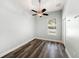Bedroom featuring light blue walls, a ceiling fan, wood-look floors, and a window view of the pool at 5189 Brackenwood Dr, Spring Hill, FL 34609