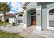 Close-up of front entrance with decorative rock landscaping and lush green lawn at 5189 Brackenwood Dr, Spring Hill, FL 34609