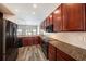 Modern kitchen with dark wood cabinets, granite countertops, and stainless steel appliances at 5189 Brackenwood Dr, Spring Hill, FL 34609