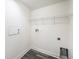 Functional laundry room with white walls, wire shelving and connections for washer and dryer at 5189 Brackenwood Dr, Spring Hill, FL 34609