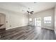 Bright living room with ceiling fan, gray floors, and sliding glass doors leading to pool at 5189 Brackenwood Dr, Spring Hill, FL 34609