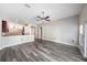 Open floor plan with gray flooring connecting living area to kitchen with breakfast bar at 5189 Brackenwood Dr, Spring Hill, FL 34609