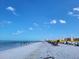 Beach view of condo building with people enjoying a beautiful sunny day at 530 S Gulfview Blvd # 303, Clearwater, FL 33767