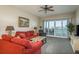 Bright living room featuring plush seating, a ceiling fan, and access to a private balcony with water views at 530 S Gulfview Blvd # 303, Clearwater, FL 33767