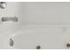 Close-up of a clean, white tiled bathtub with jacuzzi jets in a well-maintained bathroom at 5400 9Th N Ave, St Petersburg, FL 33710