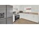 Bright kitchen with stainless steel appliances, white cabinets, and wood-look flooring at 5400 9Th N Ave, St Petersburg, FL 33710