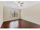 Bedroom with hardwood floors, ceiling fan, and a large window for natural light at 5717 Kingletsound Pl, Lithia, FL 33547