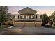 A home exterior with a stone-clad facade, balcony, three garages, and a well-kept driveway at 5717 Kingletsound Pl, Lithia, FL 33547