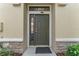 Exterior shot of front door with stone detail and plants at 5717 Kingletsound Pl, Lithia, FL 33547