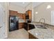 Well-lit kitchen featuring granite countertops, modern appliances, and wood cabinets at 5717 Kingletsound Pl, Lithia, FL 33547