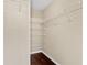 Walk-in closet features hardwood floors and ample shelving for storage at 5717 Kingletsound Pl, Lithia, FL 33547