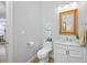 Half bathroom featuring marble countertops, tile flooring, and rattan framed mirror at 6 Academy S Way # 23A, St Petersburg, FL 33711