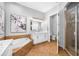 Well-lit bathroom featuring a double vanity, a soaking tub, and a separate glass-enclosed shower at 6 Academy S Way # 23A, St Petersburg, FL 33711