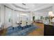 Bright dining room with elegant chandelier, tile floors, and view into the spacious living area at 6 Academy S Way # 23A, St Petersburg, FL 33711