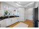 Bright kitchen features white cabinets, granite countertops, and stainless steel refrigerator with a view of the dining area at 6 Academy S Way # 23A, St Petersburg, FL 33711
