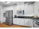 Bright kitchen features stainless appliances, granite counters, and white cabinets, providing a modern and functional space at 6 Academy S Way # 23A, St Petersburg, FL 33711