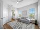 Bright living room with hardwood floors, a cozy sofa, and an open doorway to the bathroom at 6 Academy S Way # 23A, St Petersburg, FL 33711