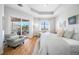 Bright main bedroom with ceiling fan, light hardwood floors, a large bed, and an outdoor balcony at 6 Academy S Way # 23A, St Petersburg, FL 33711