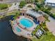 Aerial view of the community pool area featuring a water view, lounge chairs, and manicured landscaping at 6 Academy S Way # 23A, St Petersburg, FL 33711
