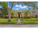 Charming yellow home featuring a Spanish tile roof, manicured lawn, and mature landscaping at 646 16Th Ne Ave, St Petersburg, FL 33704